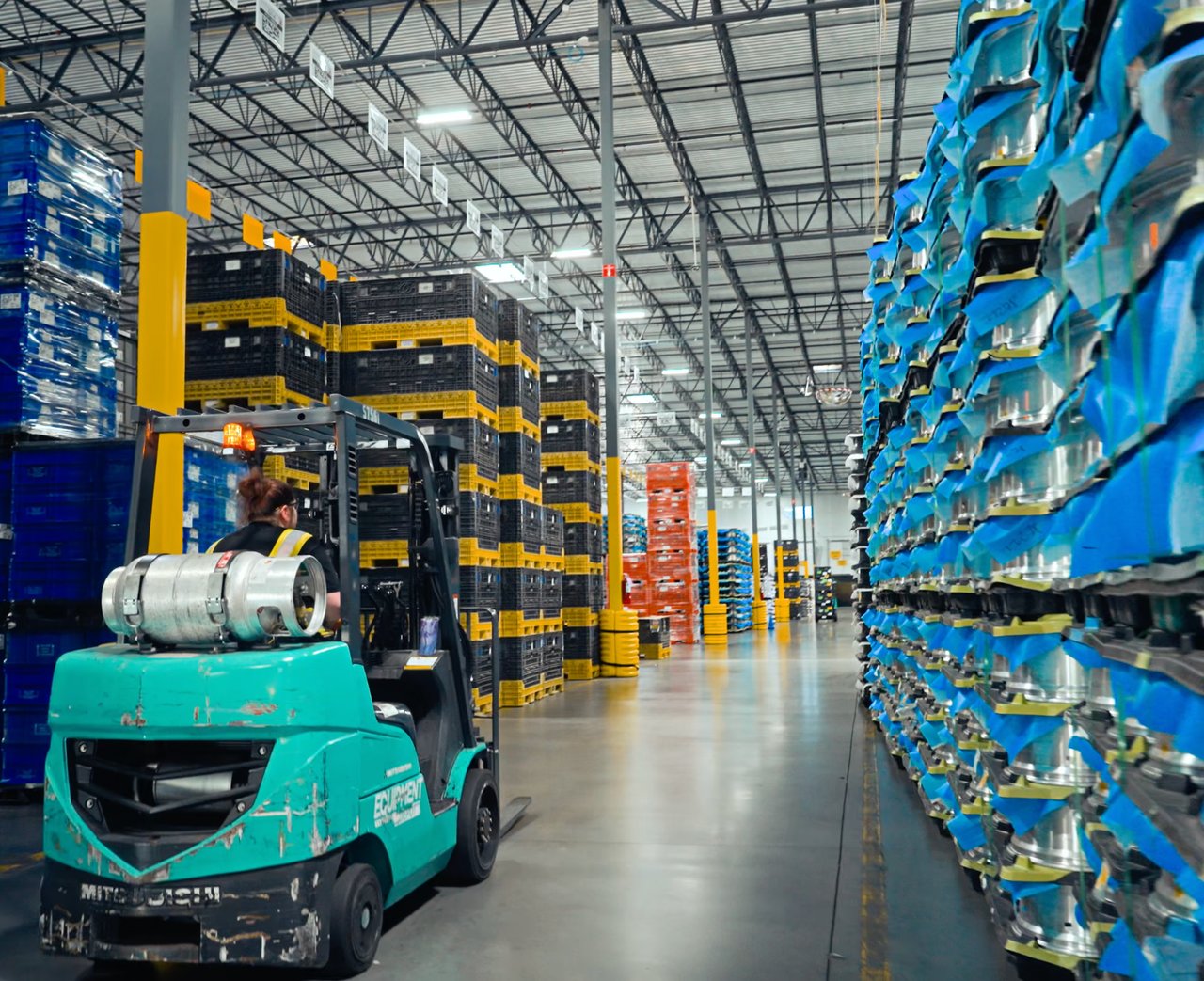 Forklift carrying materials through a warehouse aisle